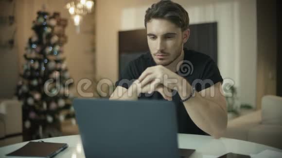 在新年家的笔记本电脑上工作的程序员男性自由职业者视频的预览图