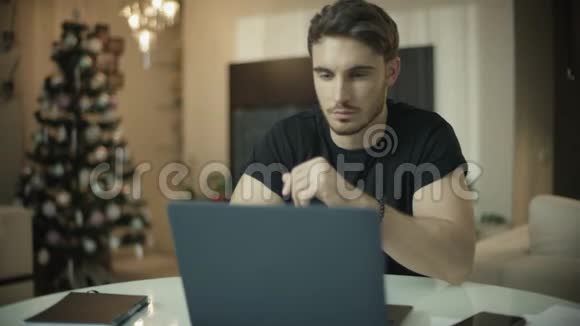圣诞节那天一个惊讶的男人在看手提电脑屏幕视频的预览图
