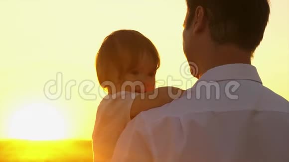 快乐的爸爸抱着他的手臂小女儿在公园里的阳光明媚爸爸带着一个小孩走路视频的预览图