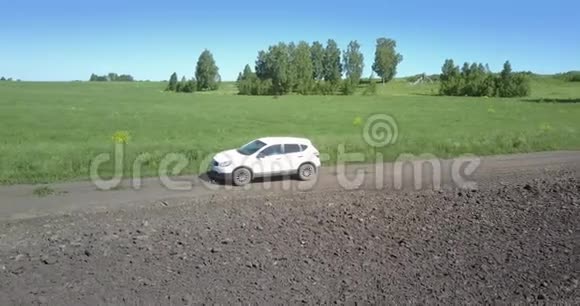 吉普车在耕地和绿地之间的道路上行驶视频的预览图