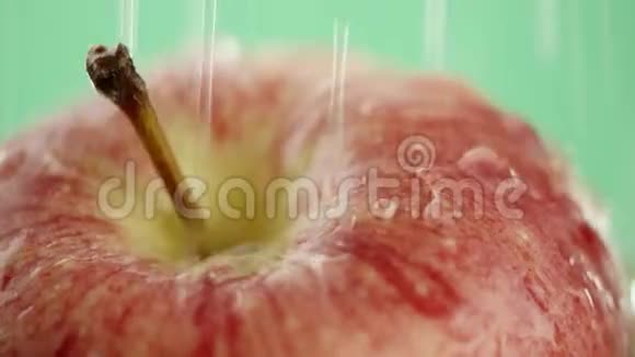 在视频中我们看到一个红苹果水从顶部像波浪一样倾泻白色背景特写视频的预览图