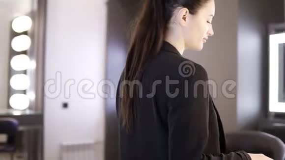 化妆用的化妆品美丽的黑发女人穿着黑色西装拿出她的工作工具造型师化妆师视频的预览图
