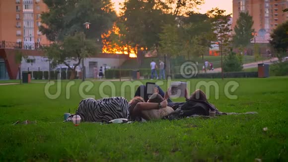 大学生读书和做白日梦时休息和躺在公园草地上的特写镜头视频的预览图