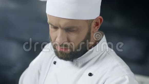 厨师在专业厨房工作把厨师脸上的食物收起来视频的预览图