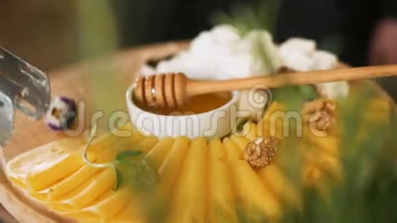 用不同的奶酪花和坚果放在木盘上的甜蜜视频的预览图