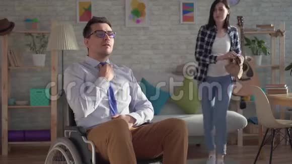 年轻女子在轮椅上为残疾丈夫准备午餐视频的预览图