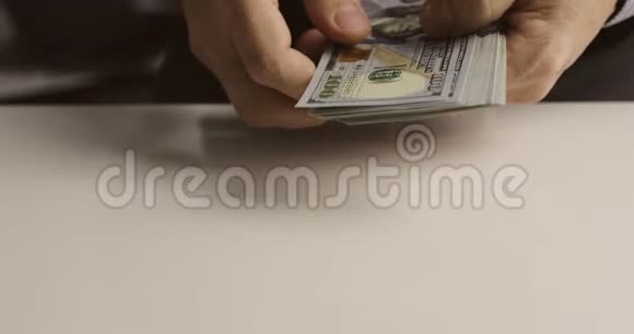 一个商人的特写他手里数着一百美元的钞票视频的预览图