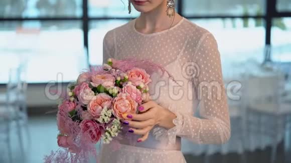 美丽的新娘穿着粉红色的裙子带着彩色的新鲜玫瑰花束视频的预览图