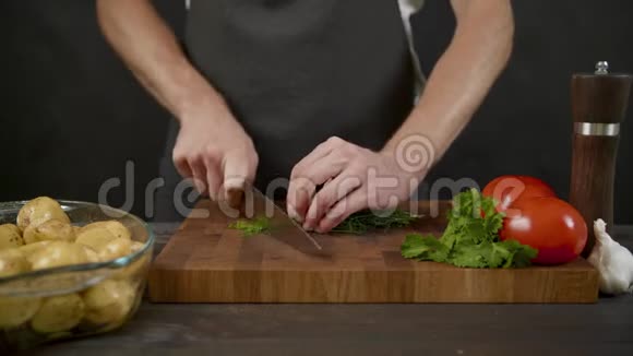 年轻厨师在阴暗的厨房切菜视频的预览图