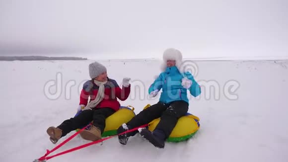 圣诞节期间一家人在冬季公园玩耍快乐的妈妈孩子们冬天在雪地里滑冰玩耍视频的预览图