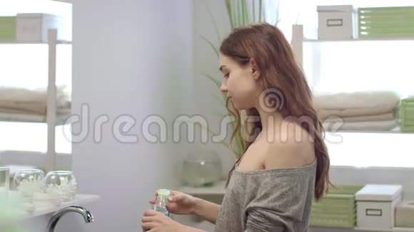 女青年用牙齿冲洗嘴浴室前镜视频的预览图