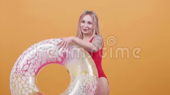 性感的金发女人游泳前戴上游泳戒指视频的预览图