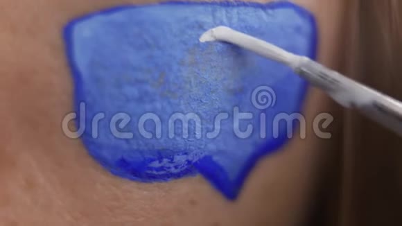 极端特写的艺术家画零在留言框上的人的皮肤使用小软刷身体艺术概念视频的预览图