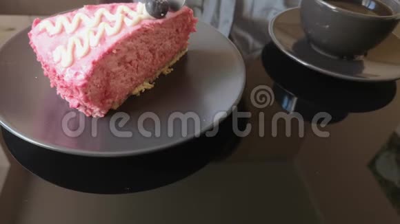 蛋糕和一杯黑咖啡在一张黑玻璃桌子上一块蛋糕女人吃奶油水果蛋糕视频的预览图