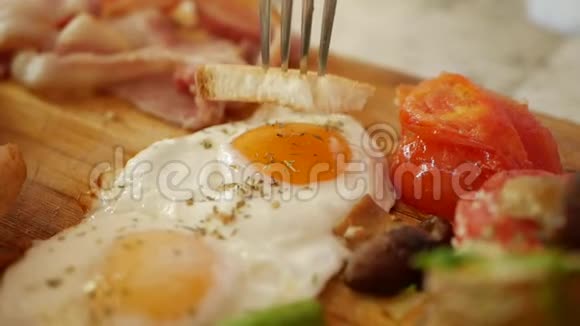 女人吃传统的英式早餐有煎鸡蛋香肠绿豆土豆蘑菇西红柿烤面包视频的预览图