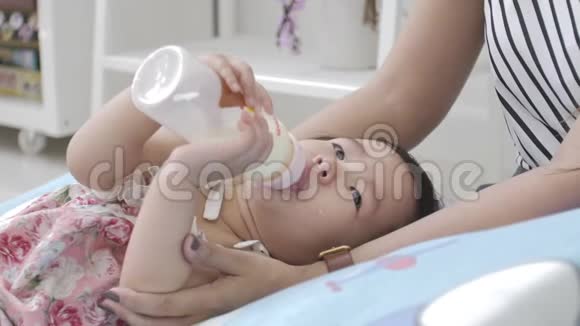 亚洲婴儿在家里和父母一起喝牛奶视频的预览图