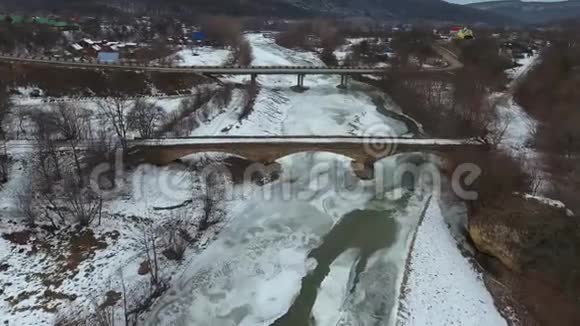 横跨冰冻河流的老桥和新桥视频的预览图