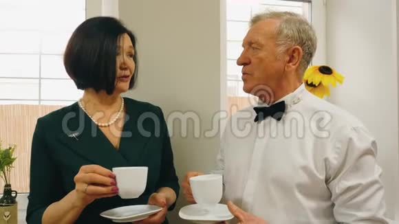 优雅的高级男女正在一起喝茶聊天视频的预览图