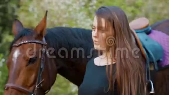带着马的女孩的肖像快乐的女孩带着一匹马走在森林里的小路上视频的预览图