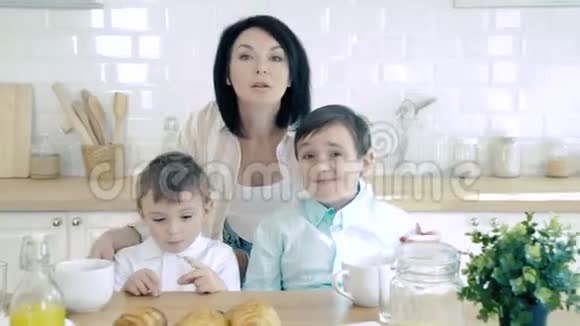 家庭幸福母亲和两个儿子在厨房的画像视频的预览图
