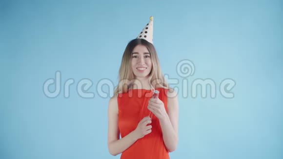 年轻女子在蓝色背景下爆炸纸屑饼干视频的预览图