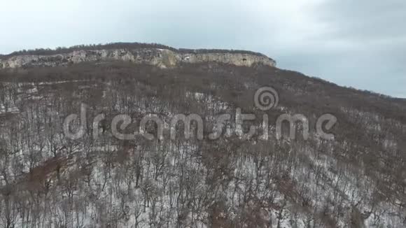 无人驾驶飞机沿山坡向岩石高原飞行视频的预览图