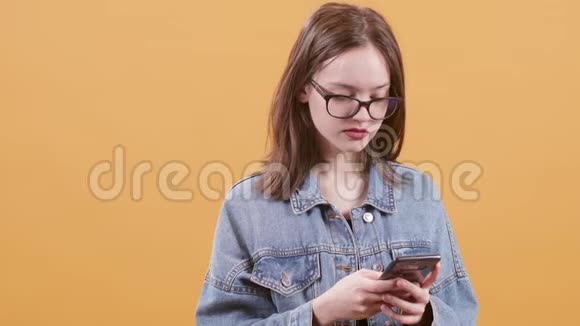 可爱的少女在智能手机上发短信似乎不耐烦视频的预览图