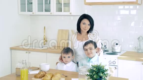 家庭幸福母亲和两个儿子在厨房的画像视频的预览图