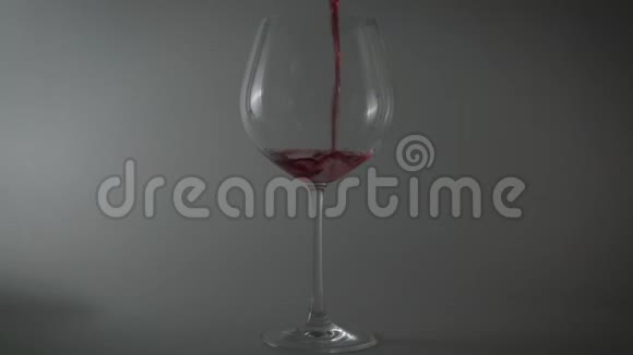 将红酒倒入杯中放在浅色背景上视频的预览图