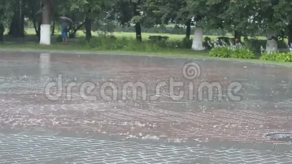 下雨了人行道上有气泡一个女人站在远处的伞下视频的预览图