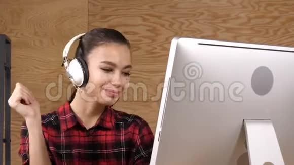 戴着耳机的快乐千禧女性放松享受音乐视频的预览图