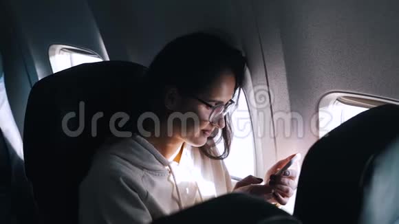 女孩在飞机里用智能手机视频的预览图