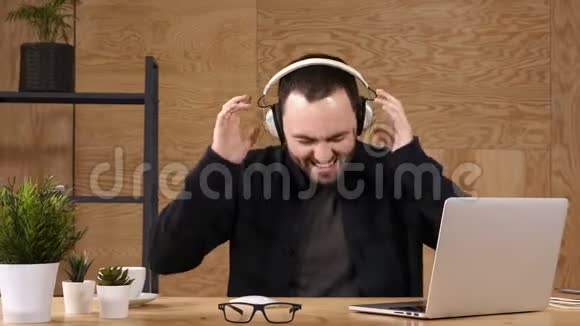 男人在耳机上听音乐情绪激动地唱歌跳舞视频的预览图