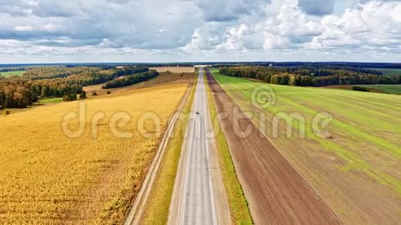 垂直飞越公路上方空中飞过了两边绿油油的田野飞越上空视频的预览图