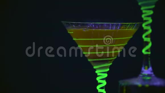 关闭鸡尾酒杯充满饮料和干冰在酒吧精彩的表演五颜六色的灯光引导慢动作4K视频的预览图