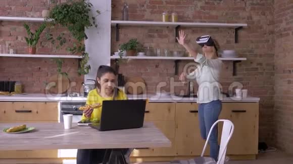 未来就是现在戴着虚拟现实眼镜的年轻女性一边玩游戏一边和同事吃饭一边交流视频的预览图