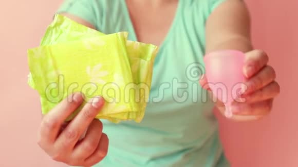 女人手拿着不同类型的女性卫生用品月经杯和卫生巾零浪费概念视频的预览图