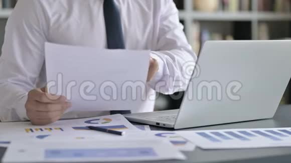 商务人士使用笔记本电脑及文件的特写镜头视频的预览图