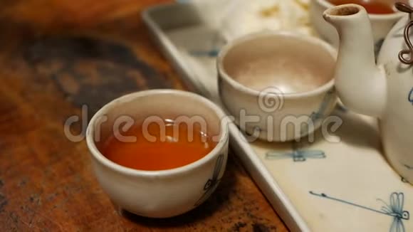 在咖啡馆的木桌上用红茶把蜂蜜倒入小碗里视频的预览图