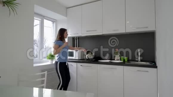 有趣的家庭主妇在家厨房做饭的时候女人手拿盘子跳舞唱歌视频的预览图