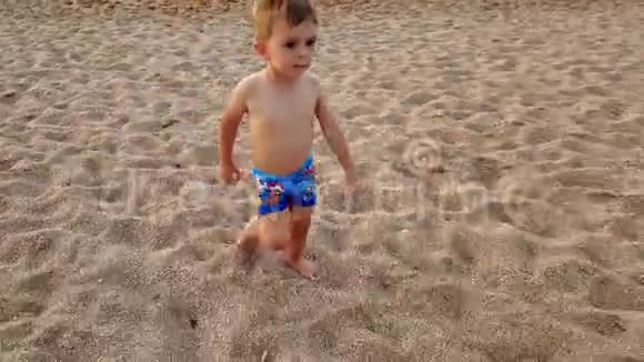 4k视频3岁小孩日落时在沙滩上散步视频的预览图