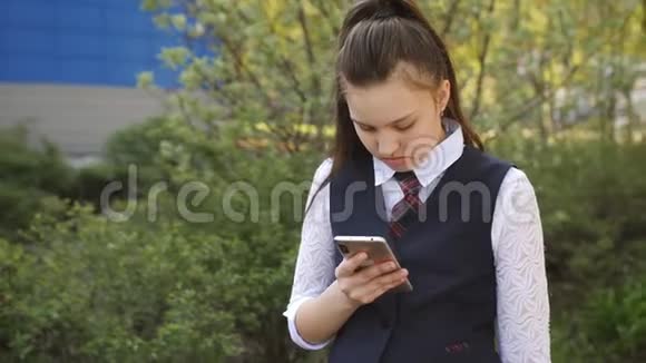 女学生在学校大楼附近的智能手机上阅读这条信息视频的预览图