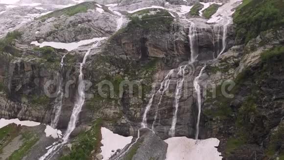 空中观景无人机拍摄到几条瀑布从陡峭的大山岩上流下来这些岩石被郁郁葱葱地包围着视频的预览图