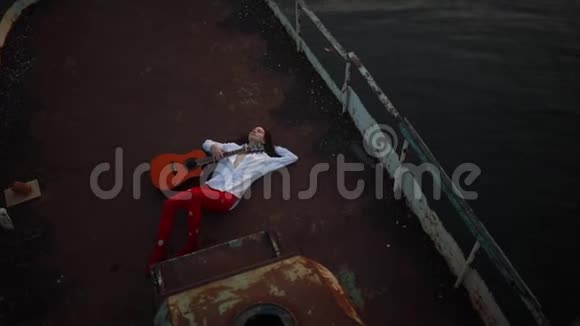 女人在一艘旧船上躺着吉他视频的预览图