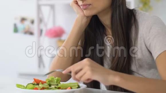 女人沉重地叹息着看着蔬菜沙拉没有食欲饮食视频的预览图
