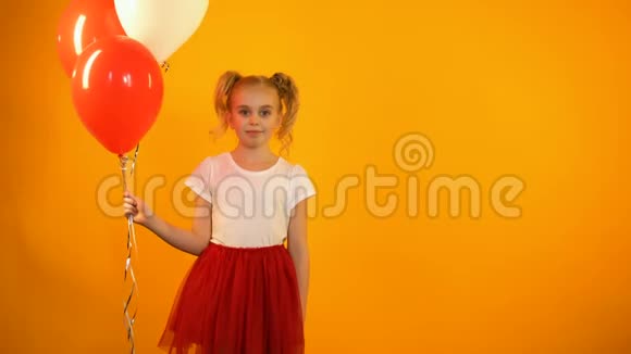 可爱的女学生拿着气球和眨眼庆祝生日聚会视频的预览图