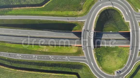 在高速公路上以环形式的形式在顶部旅行车立交桥上的空中视野从高速公路出口下高速视频的预览图