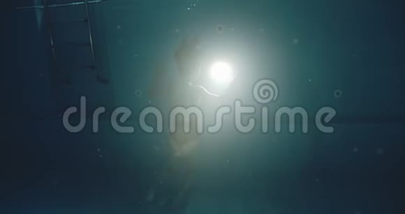 泳池里的女人在水下的戏剧性镜头视频的预览图