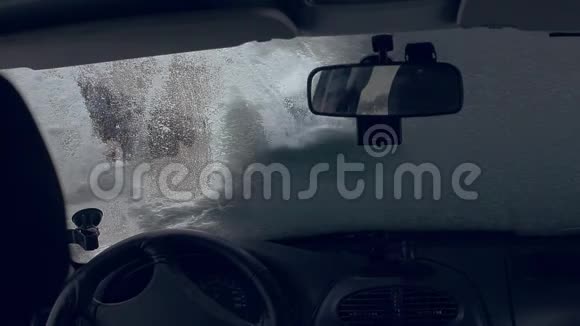 异常降雪气候变化一个男人从雪中清洁汽车视频的预览图