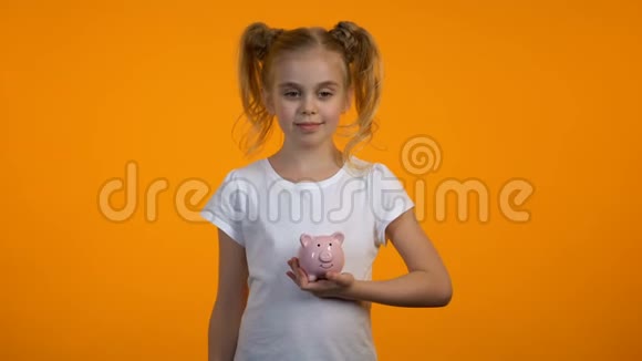 聪明的女孩把硬币放在储蓄罐里教育储蓄青少年银行视频的预览图